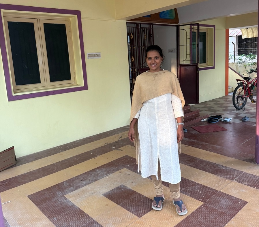 Girl standing at the entrance of Faritha Home Stay women’s hostel in Madurai – clean and secure reception area