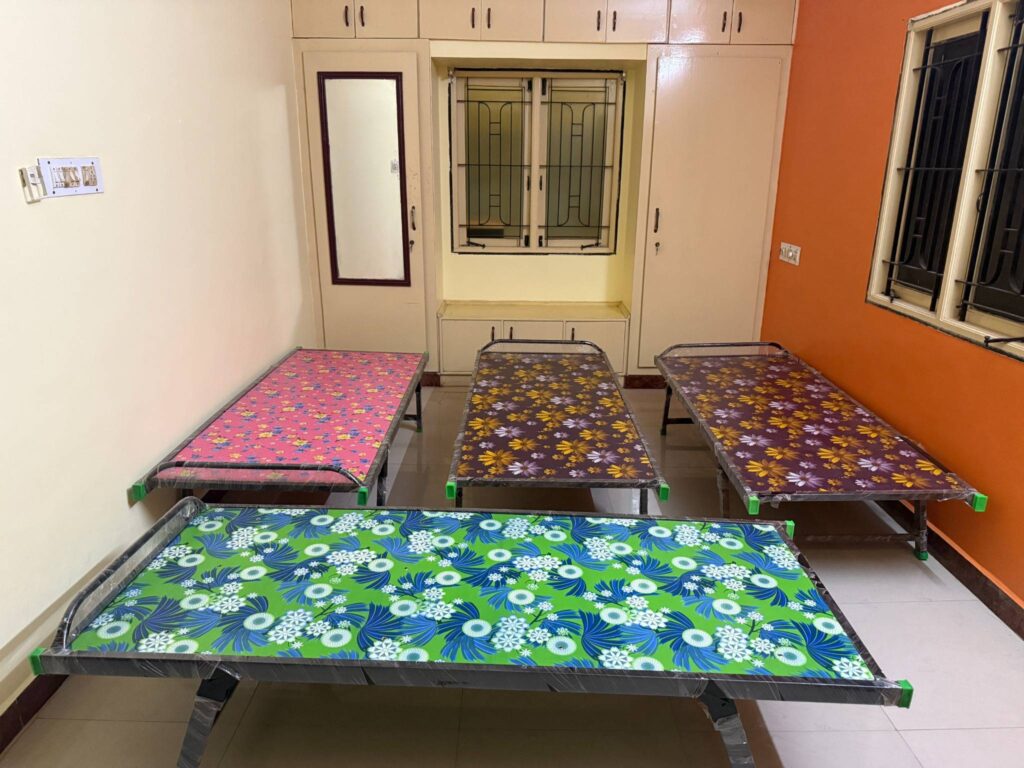4-sharing girls hostel room at Faritha Home Stay in Madurai – clean beds, bright walls, and peaceful atmosphere